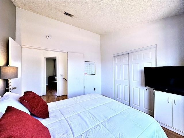 bedroom featuring hardwood / wood-style flooring, a textured ceiling, and a closet