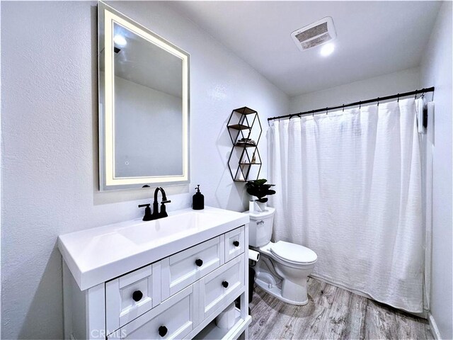 bathroom featuring toilet, wood-type flooring, vanity, and a shower with shower curtain