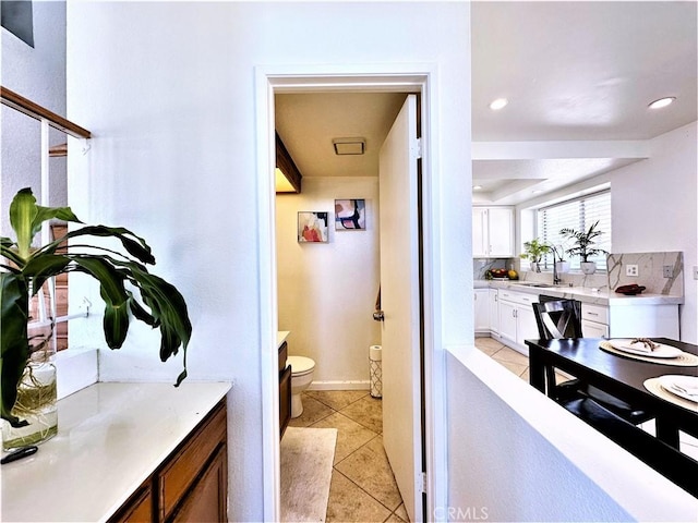 bathroom with sink, decorative backsplash, tile patterned flooring, and toilet