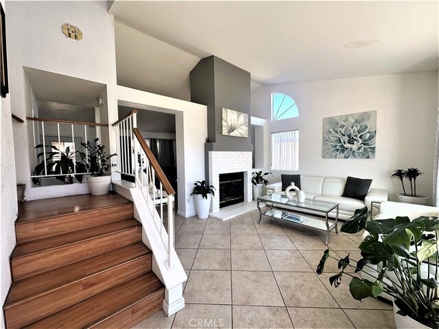 living room with a brick fireplace and light tile patterned floors