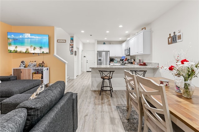 living area with recessed lighting and light wood finished floors