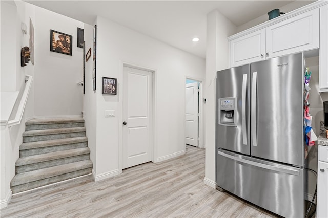 kitchen featuring light hardwood / wood-style flooring, stainless steel fridge, and white cabinets