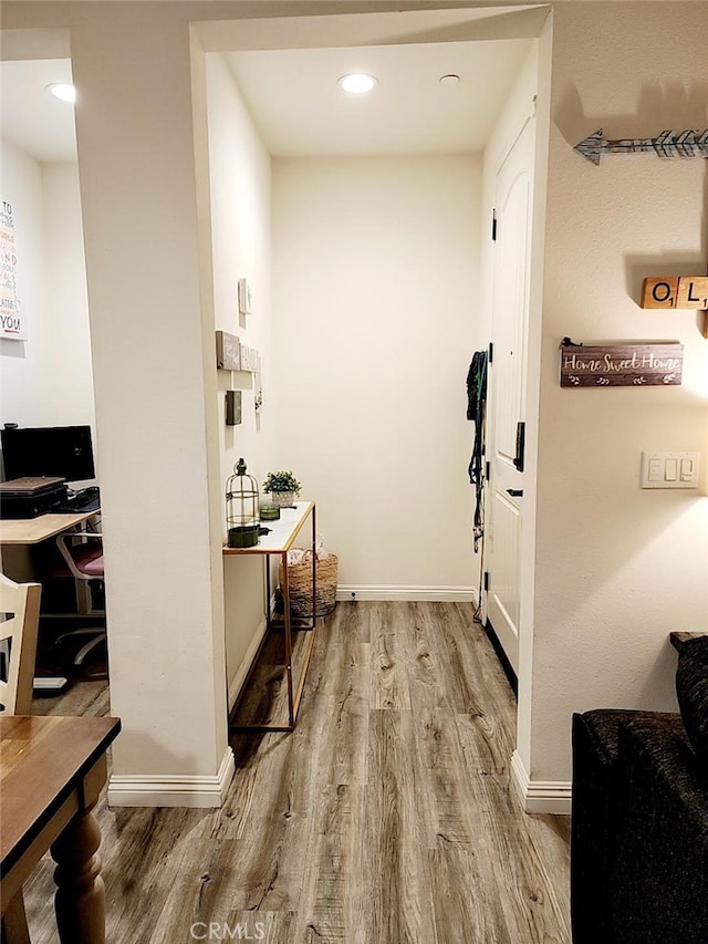 hallway featuring recessed lighting, wood finished floors, and baseboards