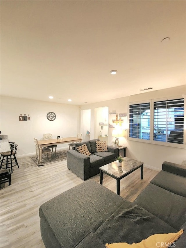 living room with baseboards, wood finished floors, visible vents, and recessed lighting