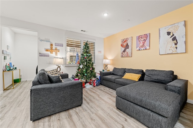 living room with baseboards, visible vents, and wood finished floors