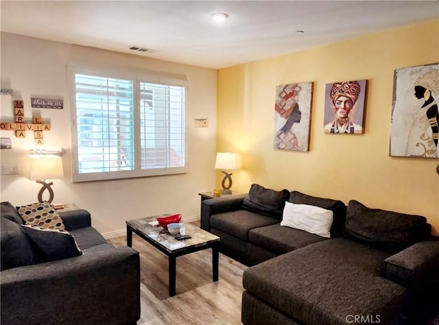 living area featuring wood finished floors, visible vents, and baseboards