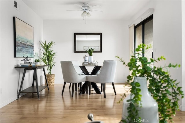 dining space with ceiling fan and wood-type flooring