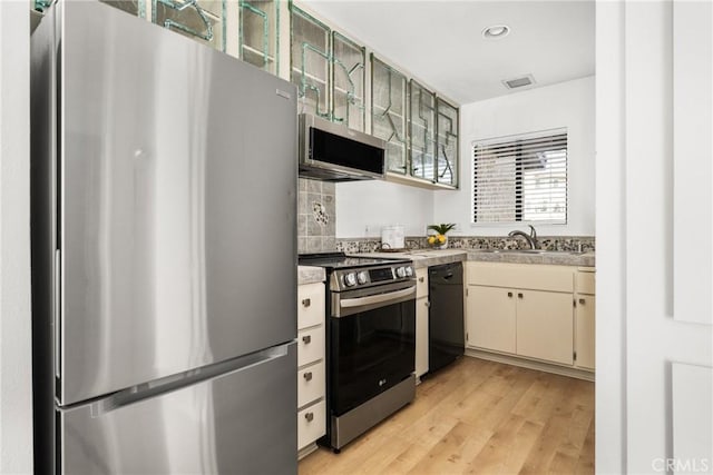 kitchen featuring light countertops, visible vents, appliances with stainless steel finishes, light wood-style floors, and a sink