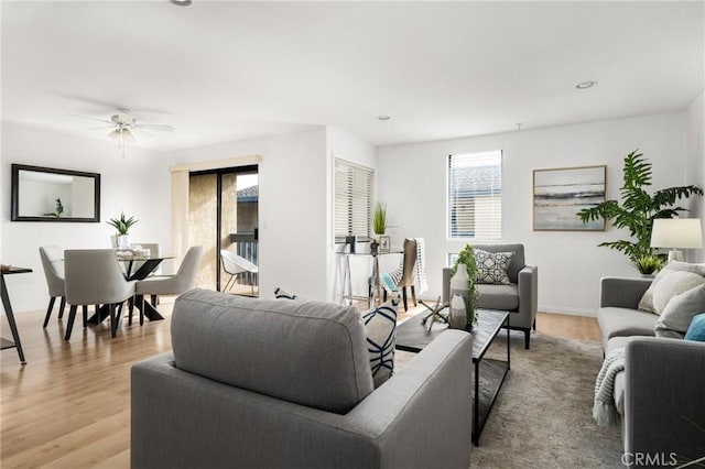 living room with ceiling fan, light hardwood / wood-style floors, and plenty of natural light