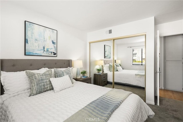 carpeted bedroom featuring visible vents and a closet