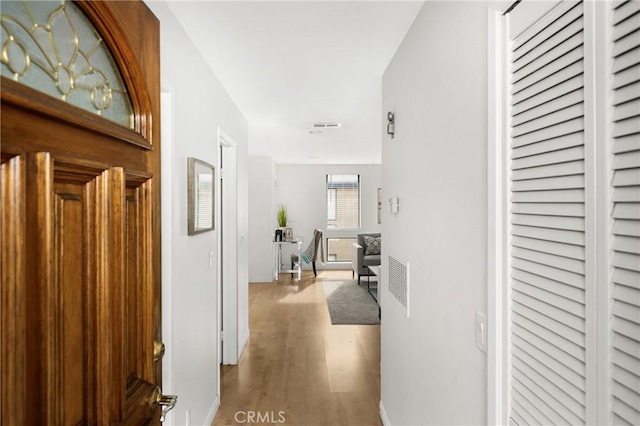 corridor with visible vents and wood finished floors