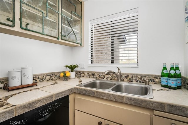 kitchen with tile counters, a sink, and dishwasher