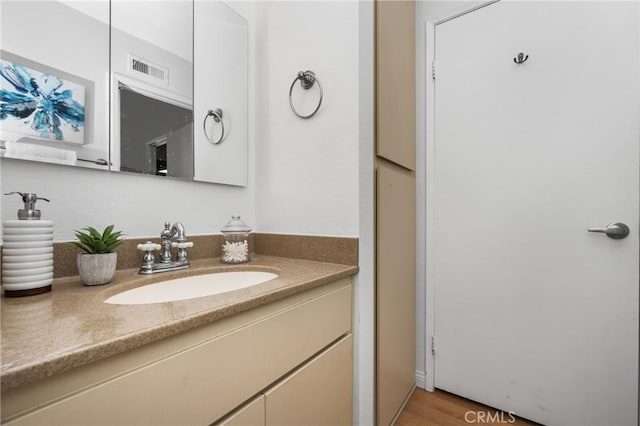 bathroom featuring visible vents, vanity, and wood finished floors