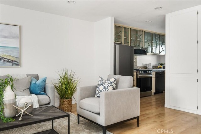 living area featuring light wood finished floors and recessed lighting