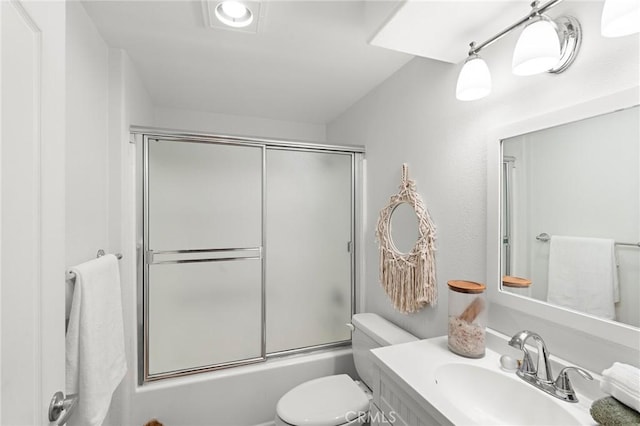 full bathroom with combined bath / shower with glass door, vanity, and toilet