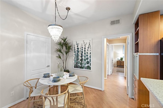 dining area featuring a chandelier and light hardwood / wood-style floors