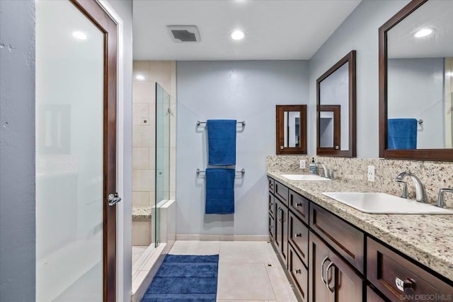 bathroom featuring walk in shower, vanity, and tile patterned flooring