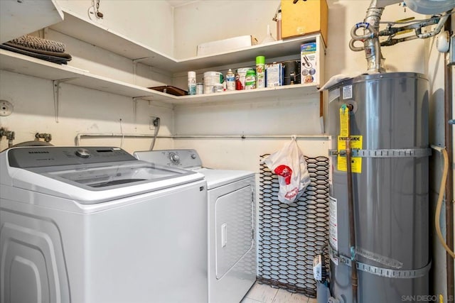 laundry room with water heater and washer and dryer