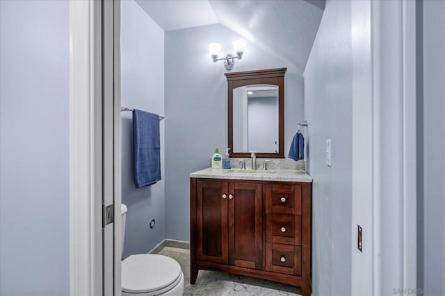 bathroom featuring toilet, lofted ceiling, and vanity