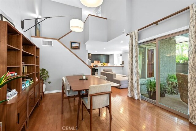 dining room featuring wood-type flooring and a high ceiling