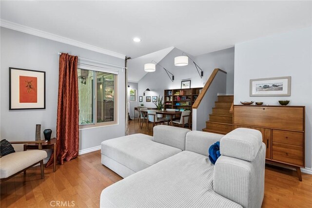 living room featuring light wood-type flooring and ornamental molding