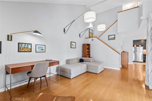 living room with high vaulted ceiling and light hardwood / wood-style flooring