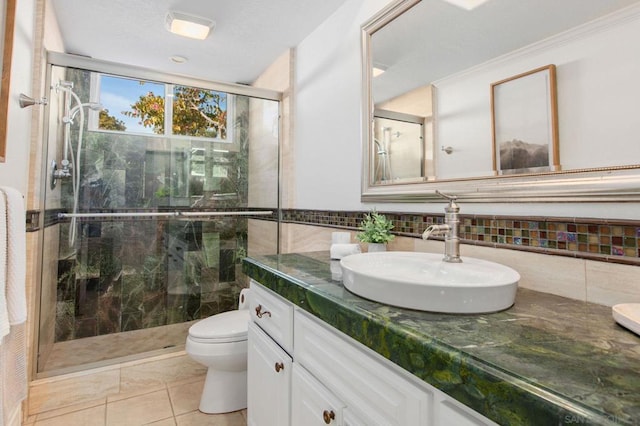 bathroom featuring toilet, vanity, tile patterned floors, and a shower with door