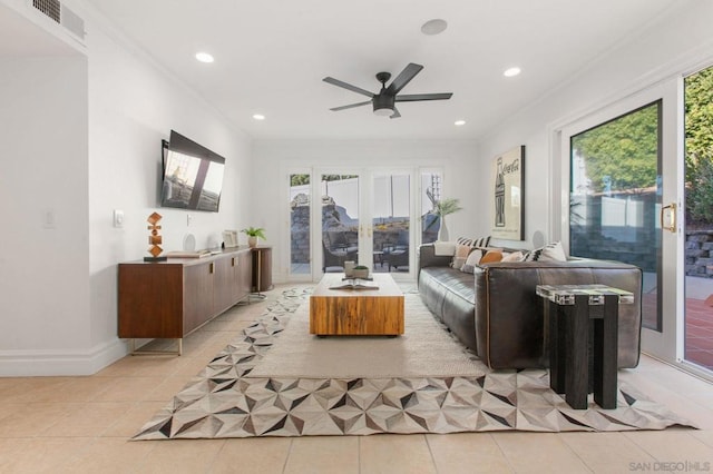 tiled living room with ceiling fan and crown molding