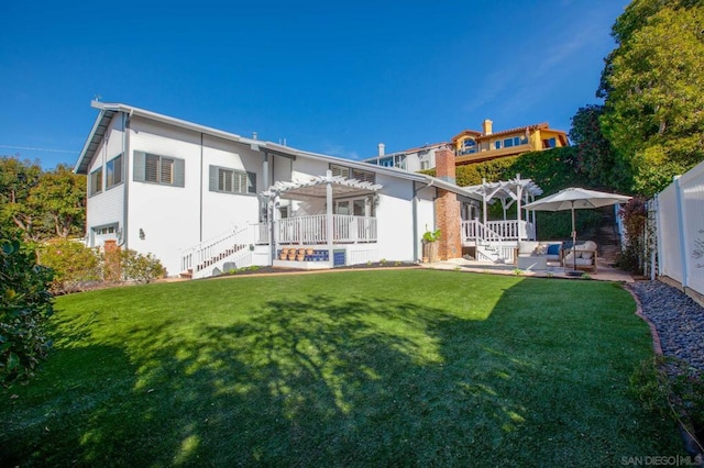 rear view of house with a pergola, a patio area, and a yard