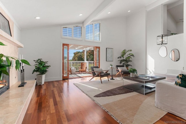 living room featuring a high end fireplace, hardwood / wood-style floors, and beamed ceiling