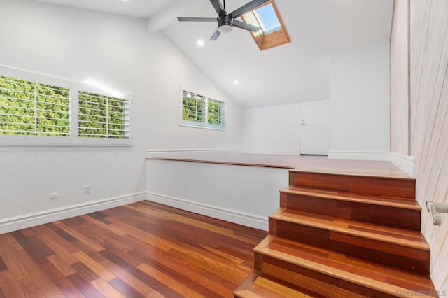 stairs featuring a skylight, ceiling fan, wood-type flooring, high vaulted ceiling, and beamed ceiling