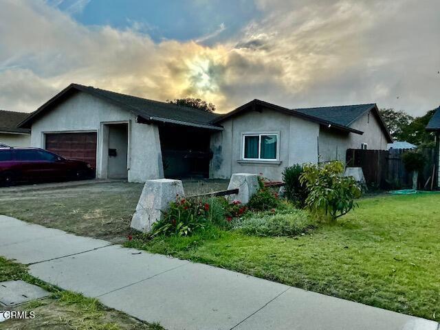 single story home with a garage and a yard