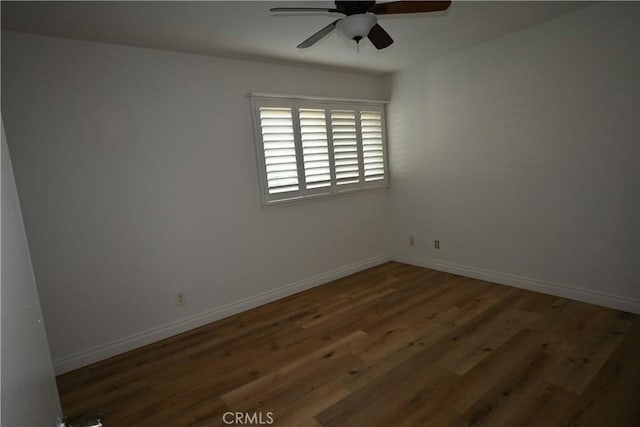 empty room featuring ceiling fan and dark hardwood / wood-style flooring