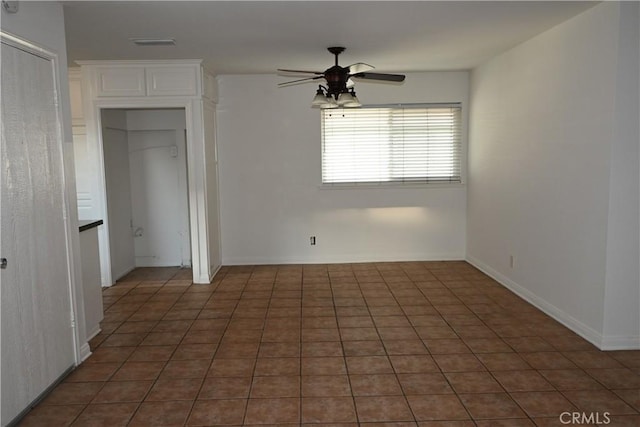 unfurnished bedroom featuring ceiling fan and dark tile patterned flooring