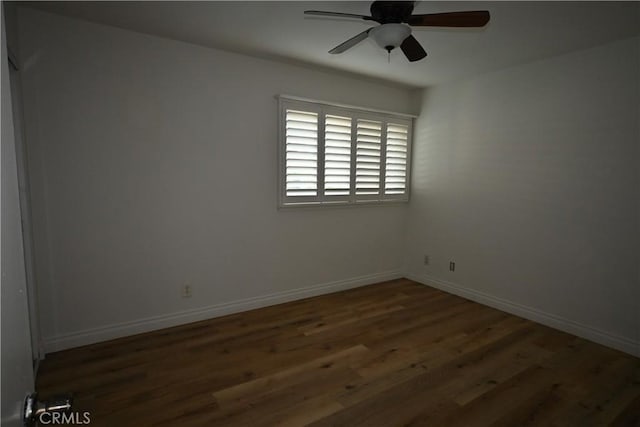 spare room with ceiling fan and dark wood-type flooring