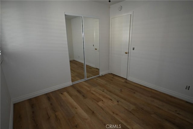 unfurnished bedroom with a closet and wood-type flooring