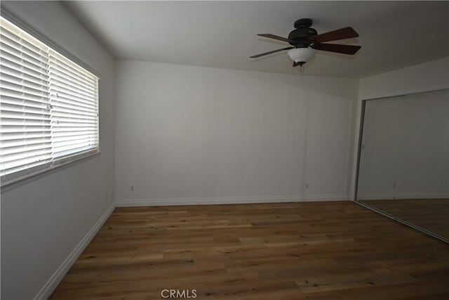 empty room featuring ceiling fan and dark hardwood / wood-style flooring