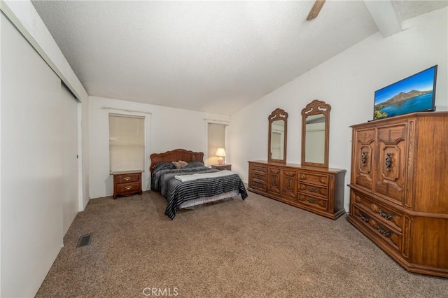 bedroom featuring ceiling fan, carpet, a closet, and beam ceiling