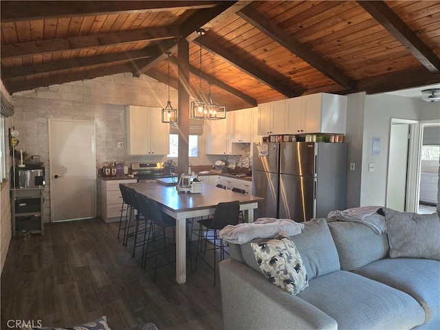 kitchen with wood ceiling, decorative light fixtures, dark wood-type flooring, stainless steel fridge, and lofted ceiling with beams