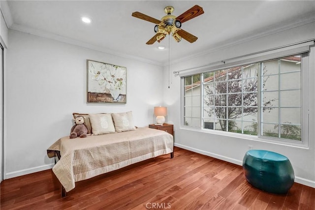 bedroom featuring ceiling fan, hardwood / wood-style flooring, and ornamental molding