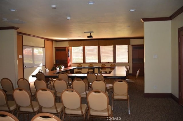 dining space with dark colored carpet, ornamental molding, and a healthy amount of sunlight