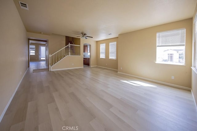 unfurnished living room with ceiling fan, plenty of natural light, and light hardwood / wood-style flooring