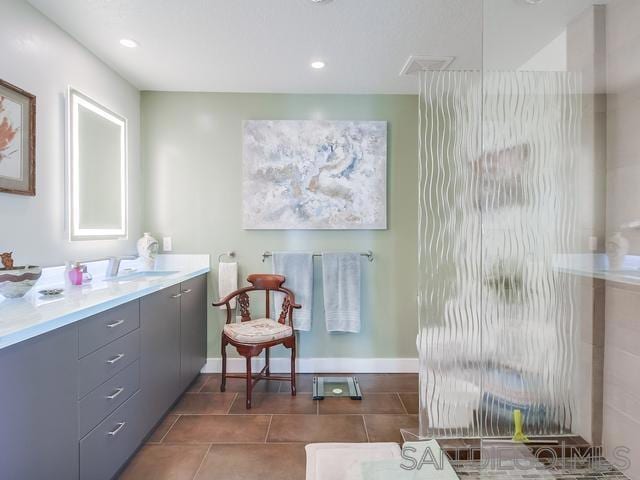 bathroom with tile patterned floors, a shower with shower door, and vanity