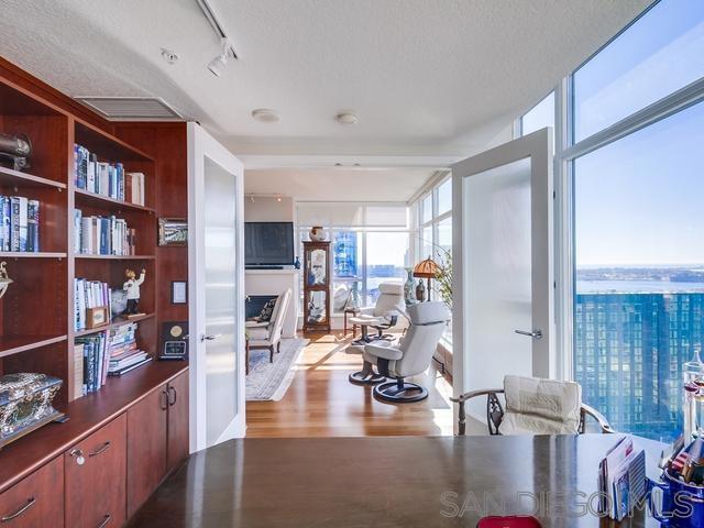 office space featuring floor to ceiling windows, a textured ceiling, and light hardwood / wood-style flooring