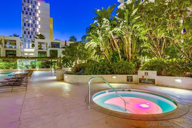 view of pool with a hot tub and a patio