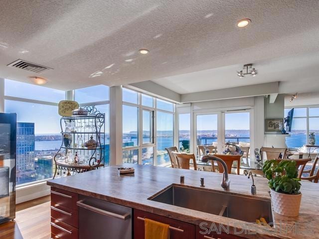 kitchen featuring a textured ceiling, a water view, and sink