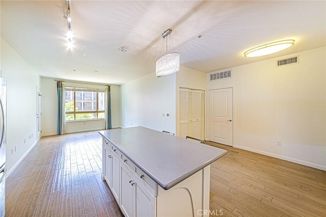 100 S Alameda St Unit 307, Los Angeles, CA 90012 - kitchen with open floor plan, rail lighting, light wood-type flooring, and a kitchen island