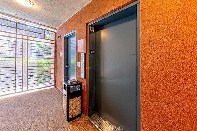 100 S Alameda St Unit 307, Los Angeles, CA 90012 - hallway with elevator, a textured ceiling, and carpet floors