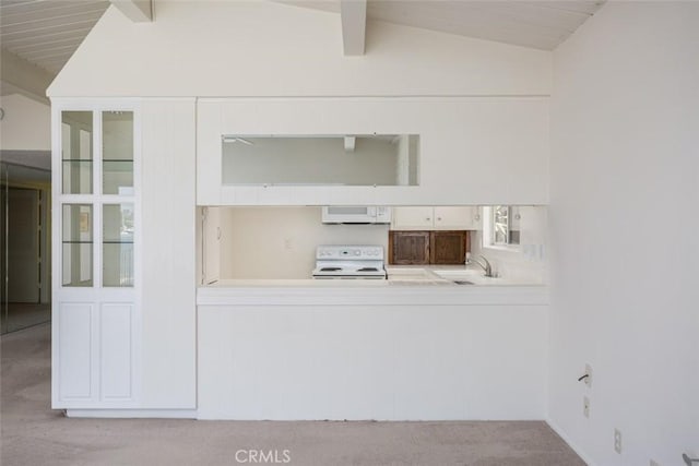 kitchen featuring white appliances, light carpet, and lofted ceiling with beams