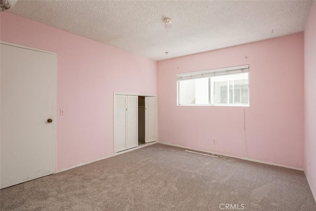 unfurnished bedroom with a textured ceiling and carpet flooring